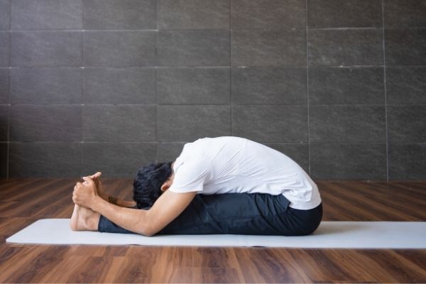 Lady practising traditional Pranayama infront of temple, guided by Yoga teacher Online